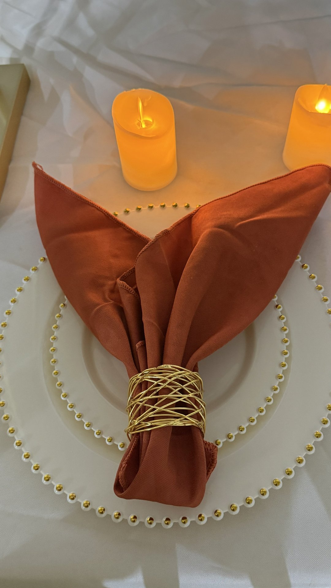 Terracotta table setting with pearl charger and candles